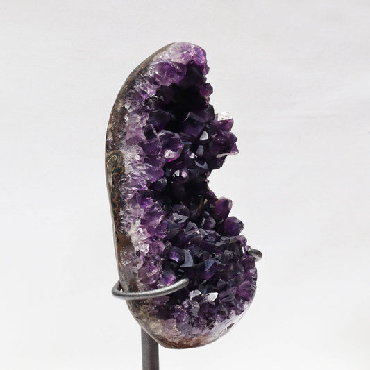 On stand frosty crystal peaks amethyst geode fragment. Raw basalt back.