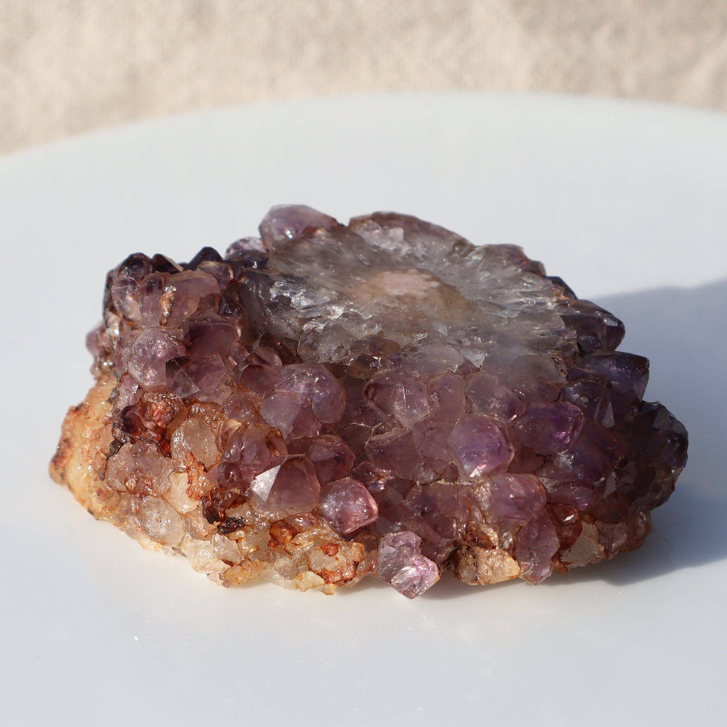 The most stunning composition of minerals in this rare cut stalactite piece of rich orange and pinkish tones. Quartz crystals of various colors surround the stalactite slice in a magical way.