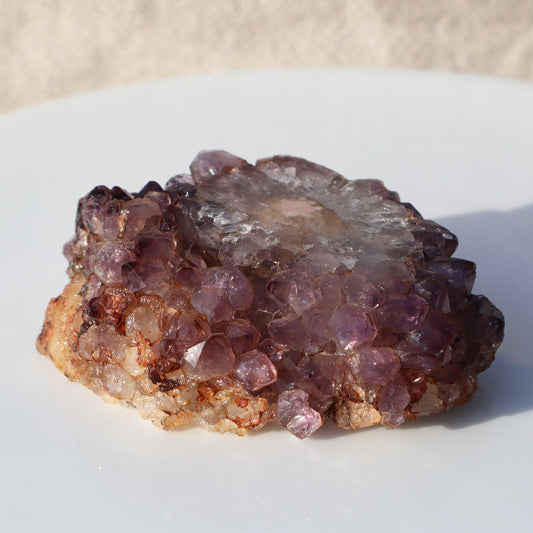 The most stunning composition of minerals in this rare cut stalactite piece of rich orange and pinkish tones. Quartz crystals of various colors surround the stalactite slice in a magical way.