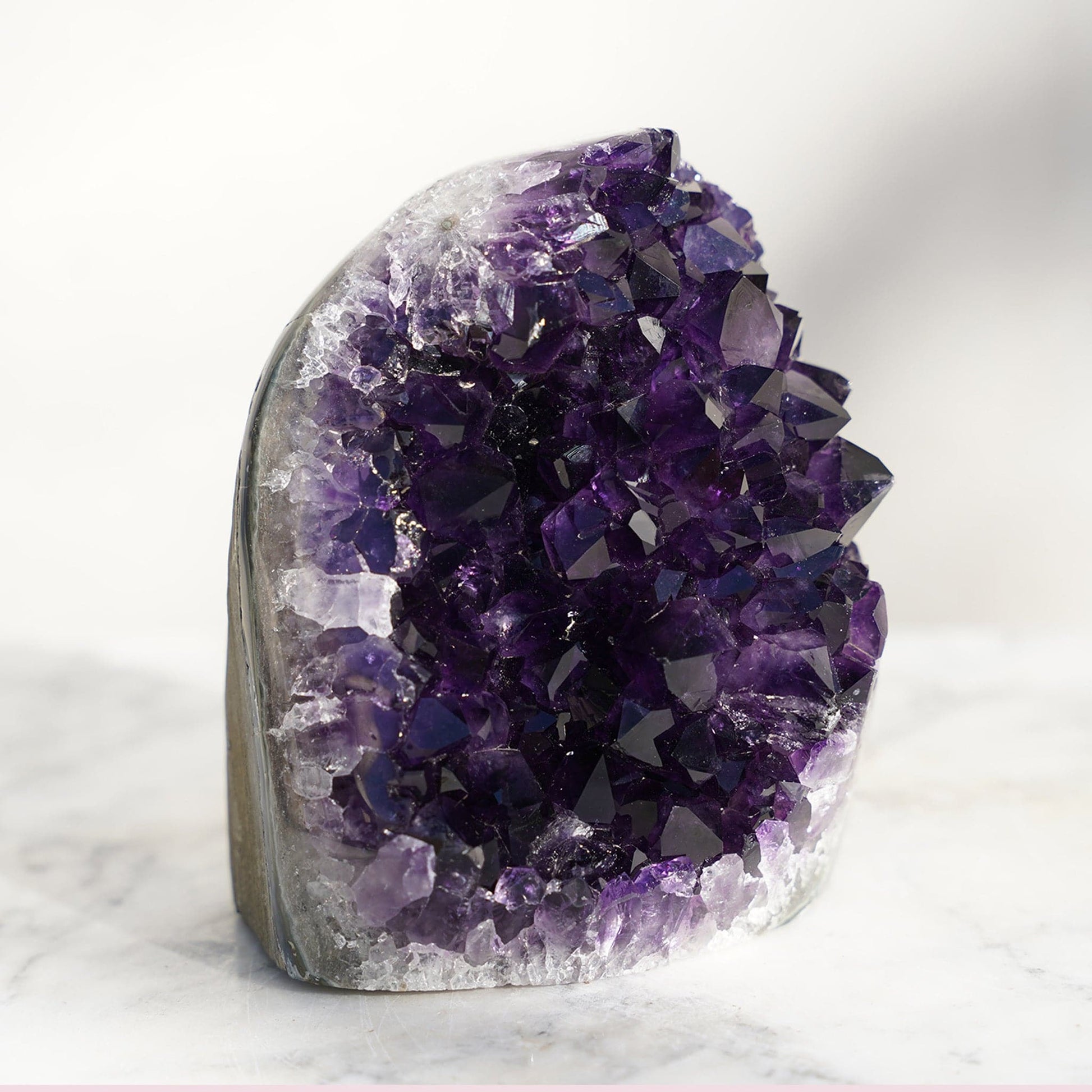 Amethyst geode of cut base style. Gem-Grade quality crystal peaks. exceptional bands of green celadonite, delightful blue agate, and white quartz meeting the raw back basalt.