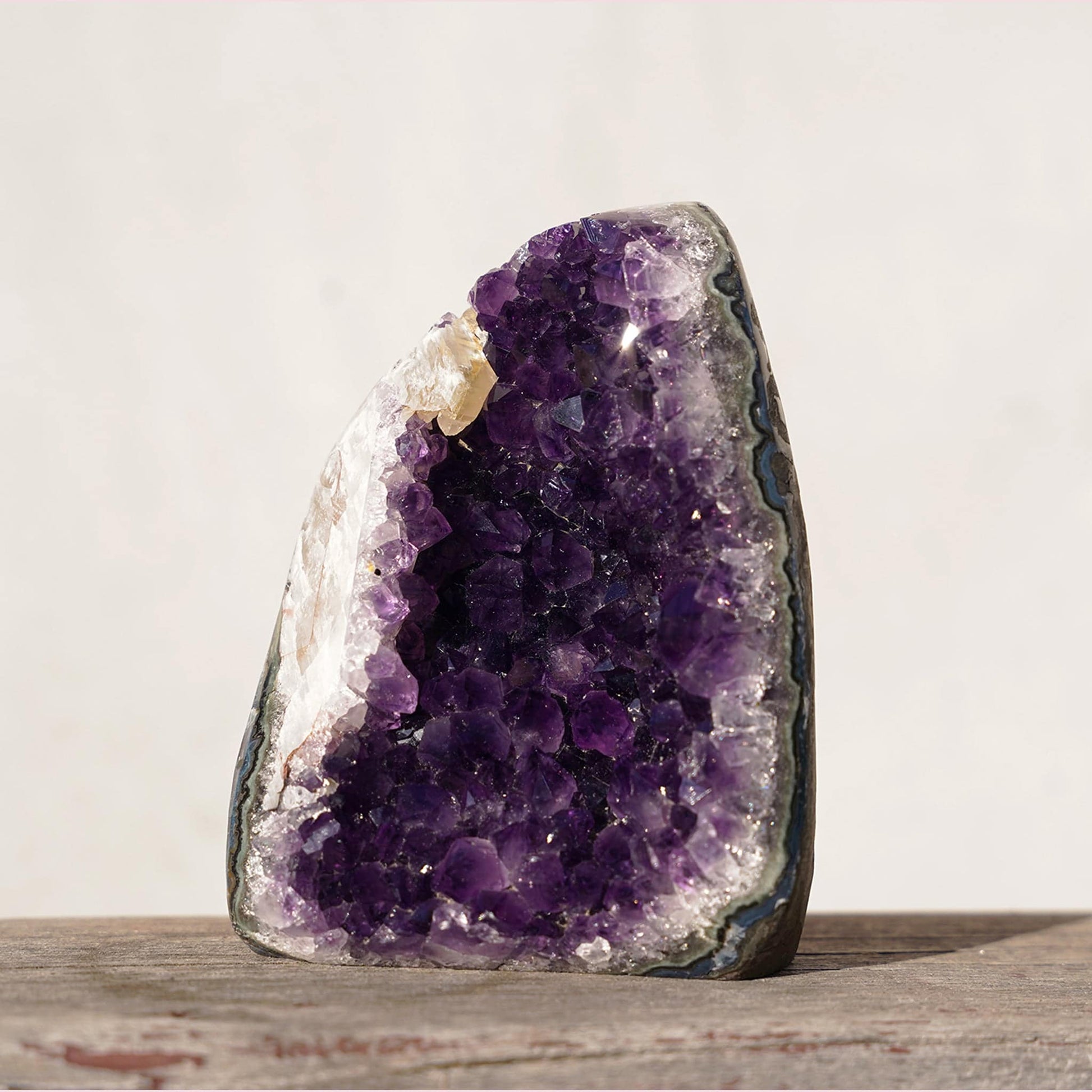 Amethyst geode cathedral-style with exquisite honey-color calcite formation. Opening in the basalt to explore green and bluish layers of agate and celadonite bands.
