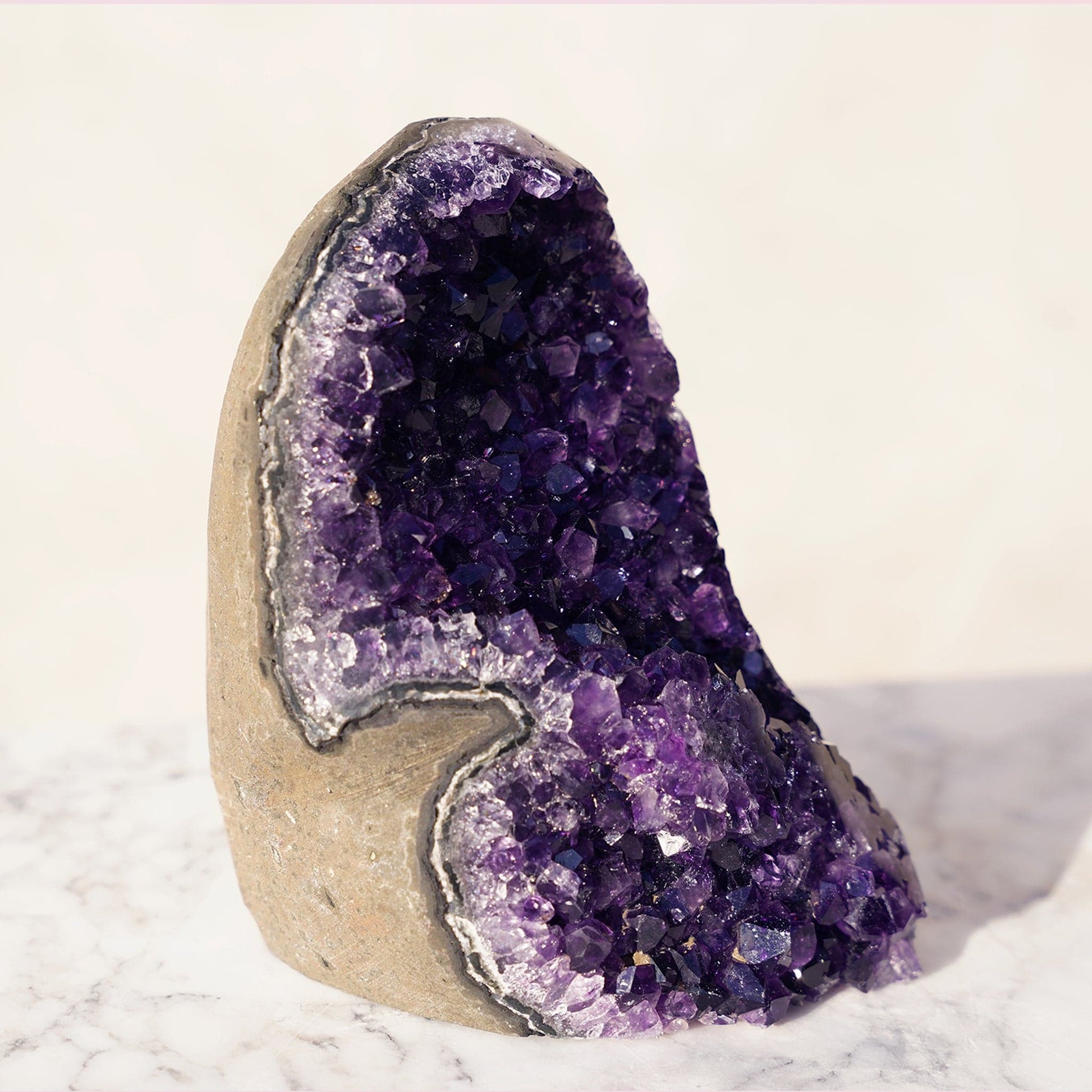 Cut-base amethyst geode with stunning multi-toned purple peaks, just to reveal an even more complex composition of fascinating details. Stalactites and true light-reflecting crystal peaks.