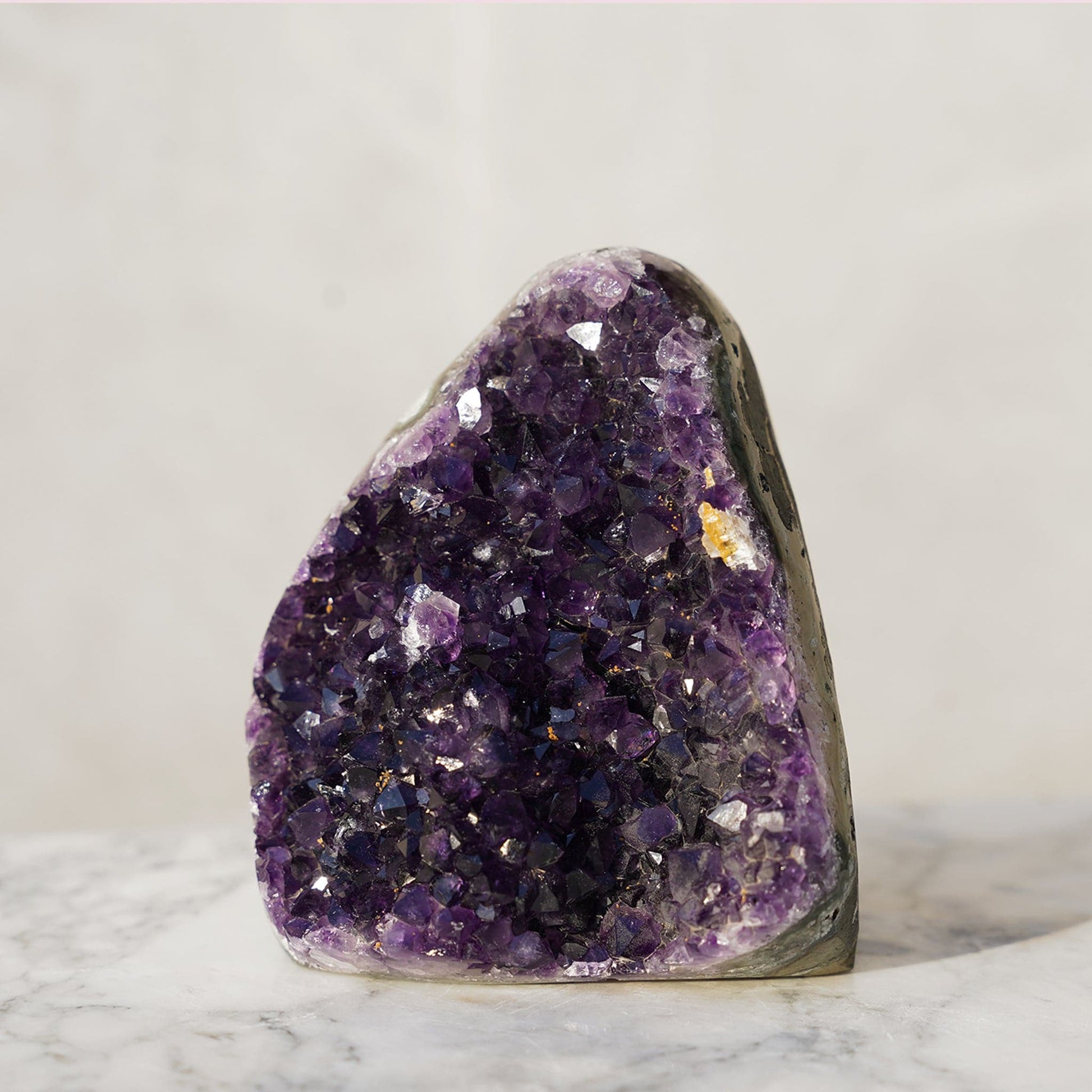 Amethyst cathedral cut with a delicate yellow calcite detail.  Beyond the intense purple peaks, layers of green and blue agate and celadonite frame this unequaled geode piece.. 