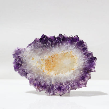 Large amethyst stalactite slice. Impressively transparent allowing light to pass through as the mineral composition of this piece offers nearly one hundred percent crystals, including the center of this gorgeous slice. Its crystals, in a variety of colors from intense yellow to colorless, to rich purple.