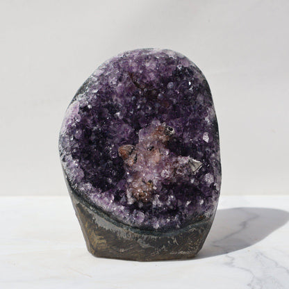 Intense purple stand-alone amethyst offering a center mauve-pink Seastar design. Green celadonite meets with the back basalt.